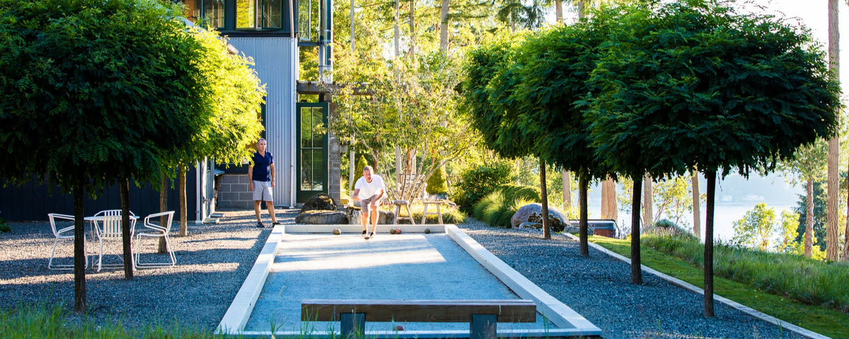 Two men playing bocce on a Boccemon surfaced bocce court on Mercer Island, Washington.