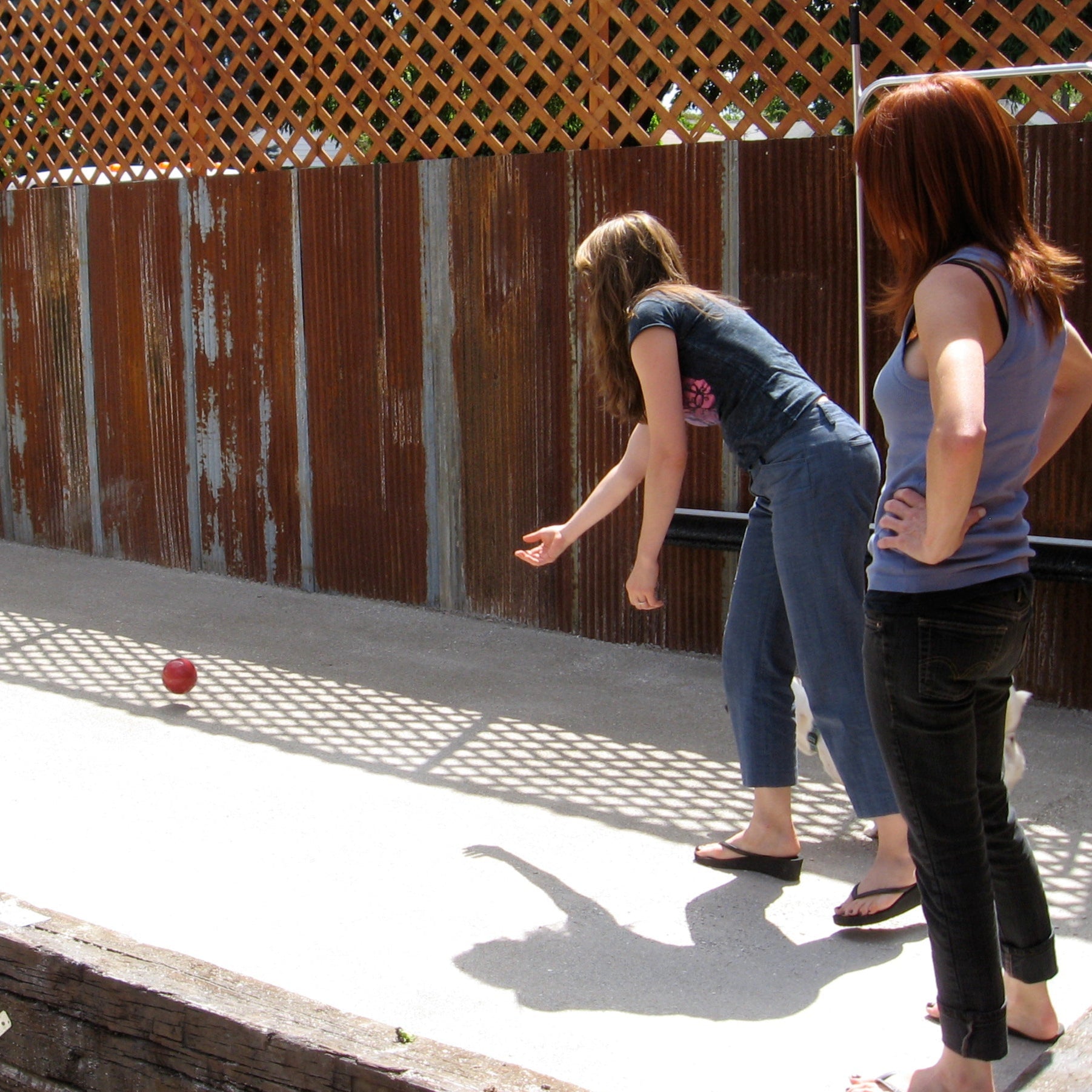 Two white women playing bocce at a pub